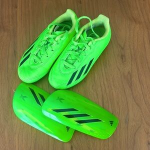 Gently used Adidas neon green 11 soccer cleats and shin gaurds